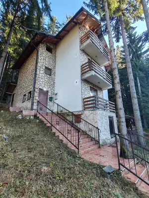 a building with a staircase in front of a house at Apartments Planinski raj in Travnik