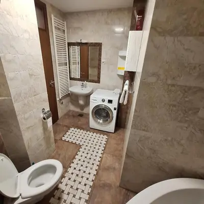 a bathroom with a toilet and a washing machine at Luks apartment in Banja Luka