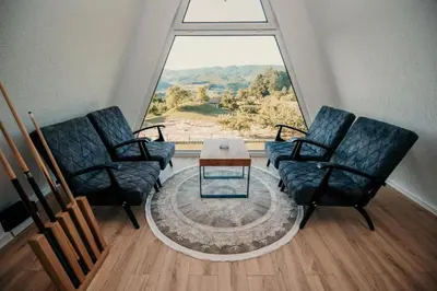 a living room with two chairs and a table in front of a window at Vila Hasandić in Visoko
