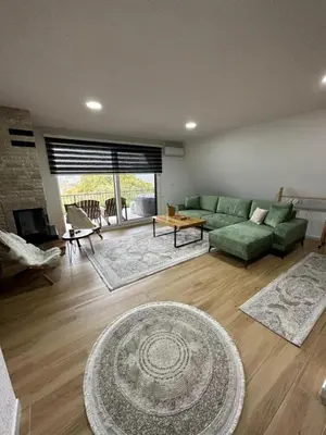 a living room with a green couch and a table at Vila Hasandić in Visoko