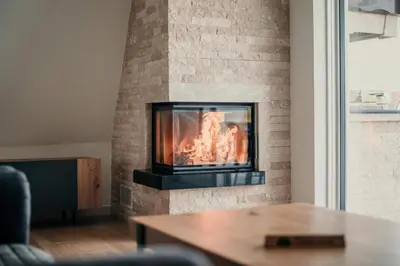 a fireplace in a living room with a table at Vila Hasandić in Visoko