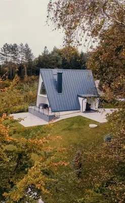 a small house with a grey roof in a field at Vila Hasandić in Visoko