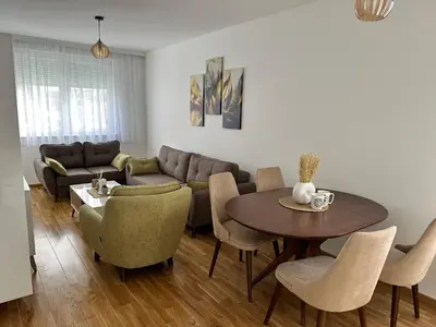 a living room with a couch and a table and chairs at SunShine Apartman CityBlock in Banja Luka