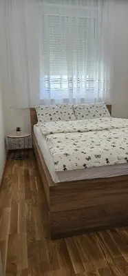 a large bed in a bedroom with a window at SunShine Apartman CityBlock in Banja Luka