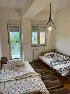 a bedroom with two beds and a pendant light at Apartman Sudnica Banja Luka in Banja Luka