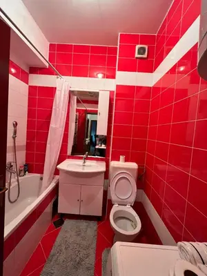 a red bathroom with a toilet and a sink at Apartman Sudnica Banja Luka in Banja Luka