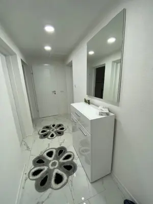 a white bathroom with a sink and a mirror at Apartment B&E in Tuzla
