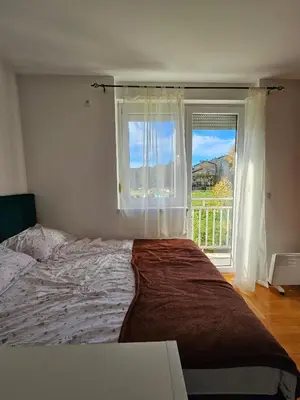 a bedroom with a large bed and a window at Apartman Lollita in Banja Luka
