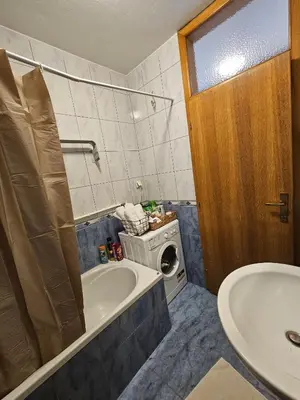 a bathroom with a tub and a washing machine at Apartman Lollita in Banja Luka