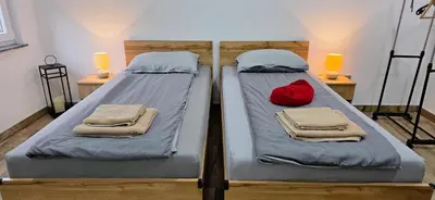 two twin beds in a room with a red pillow at Riverstone Retreat Studio in Jajce