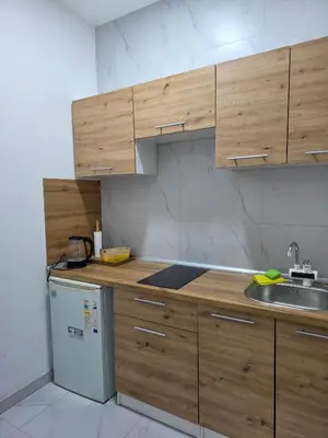 a kitchen with wooden cabinets and a sink and a dishwasher at Riverstone Retreat Studio in Jajce
