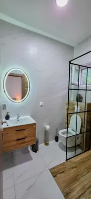 a bathroom with a sink and a mirror and a toilet at Riverstone Retreat Studio in Jajce