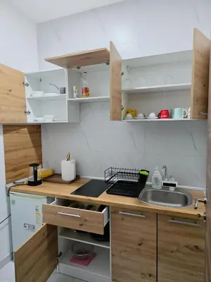 a small kitchen with wooden cabinets and a sink at Riverstone Retreat Studio in Jajce