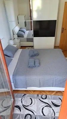 a bedroom with two beds and a flat screen tv at Apartman Greta in Livno