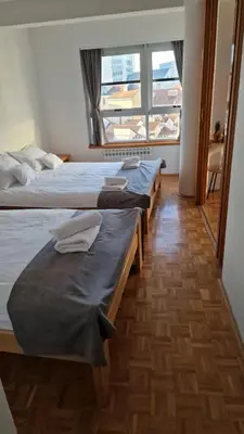 a row of beds in a room with a window at Olimpus Apartmani BD Banjaluka in Banja Luka