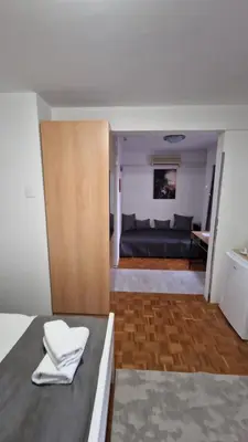 a bedroom with a bed and a couch in a room at Olimpus Apartmani BD Banjaluka in Banja Luka