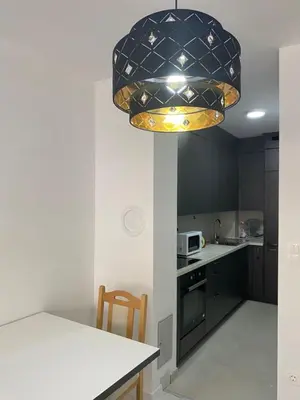 a kitchen with a large chandelier above a kitchen table at ,,Azra,, Apartment in Bihać