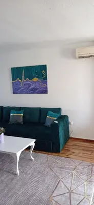 a living room with a green couch and a coffee table at Topli dom in Banja Luka