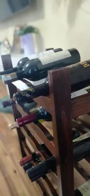 a bunch of wine bottles on a wooden rack at Topli dom in Banja Luka