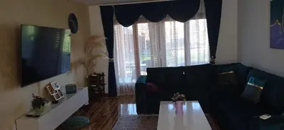 a living room with a black couch and a table at Topli dom in Banja Luka
