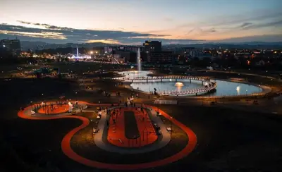 a night view of a city with a fountain at Topli dom in Banja Luka