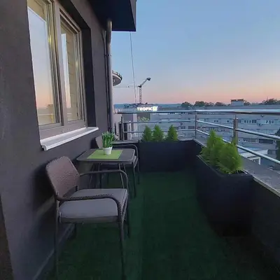 a balcony with a table and chairs on a building at Apartman Jereza Prijedor in Prijedor