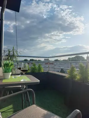 a balcony with a table and a glass of wine at Apartman Jereza Prijedor in Prijedor