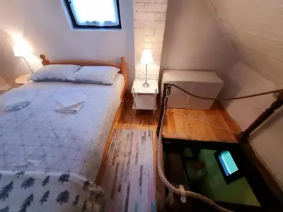 an attic bedroom with a bed and a window at Vikendica Alisa in Doboj