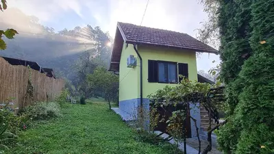 a small yellow and blue house in a yard at Vikendica Alisa in Doboj