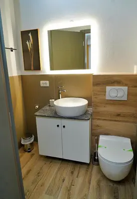 a bathroom with a sink and a toilet and a mirror at Swiss Apartmani in Banja Luka