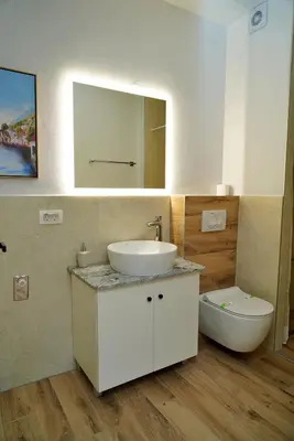 a bathroom with a sink and a toilet and a mirror at Swiss Apartmani in Banja Luka