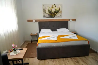 a bedroom with a large bed and a table at Swiss Apartmani in Banja Luka