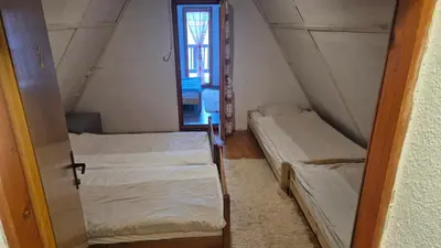 two beds in a small room with a window at VilaBellavistasmjestaj in Vlasic