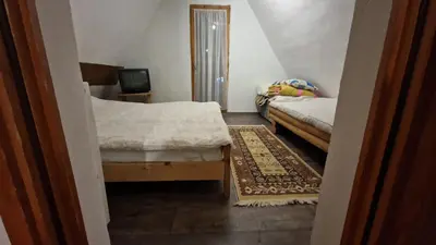 a small room with two beds and a television at VilaBellavistasmjestaj in Vlasic