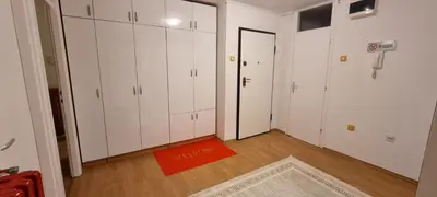 an empty room with white cabinets and an orange rug at Apartman Borik Banjaluka in Banja Luka