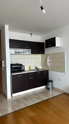 a kitchen with dark brown cabinets and a sink at Valluna Studio Apartman Kupres in Kupres
