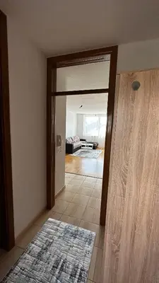 a room with an open door to a living room at Valluna Studio Apartman Kupres in Kupres