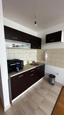 a kitchen with black cabinets and a sink at Valluna Studio Apartman Kupres in Kupres