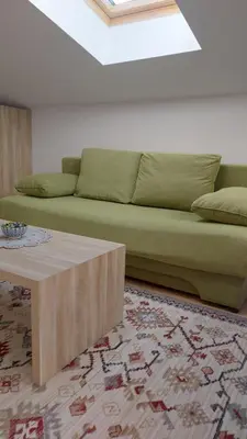 a living room with a green couch and a coffee table at Apartment XYZ Vlašić in Vlasic