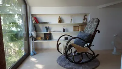 a rocking chair in a room with a window at Apartment XYZ Vlašić in Vlasic