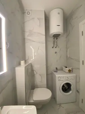 a white bathroom with a toilet and a washing machine at Mona in Banja Luka