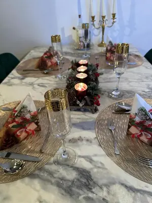a table with wine glasses and a christmas centerpiece at Apartman MRL Cavic in Banja Luka