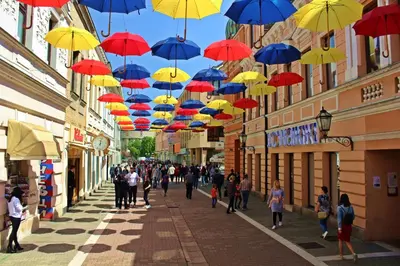a group of people walking down a street under umbrellas at Apartman MRL Cavic in Banja Luka
