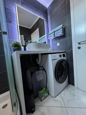 a bathroom with a washing machine and a sink at Apartman Alchemist I in Bosanska Dubica