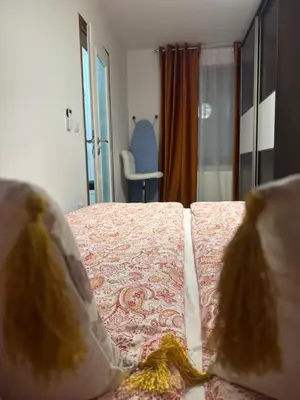 a bedroom with a bed with pillows and a chair at Apartman Alchemist I in Bosanska Dubica