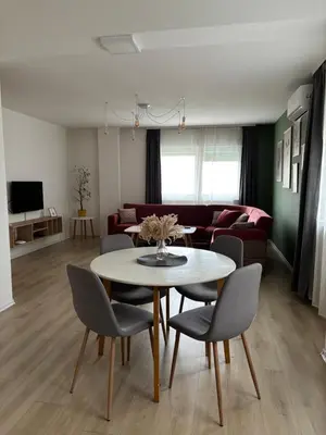 a living room with a table and chairs and a couch at Apartment Mejdan in Tuzla