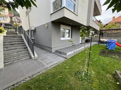 a house with stairs and a grass yard at Apartment Mejdan in Tuzla