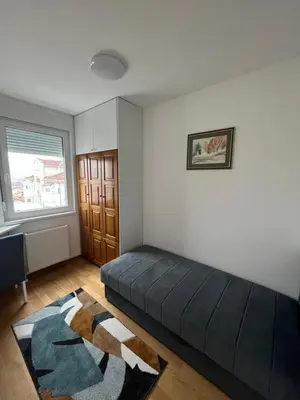 a living room with a black couch and a window at Apartman Vista Banja Luka in Banja Luka