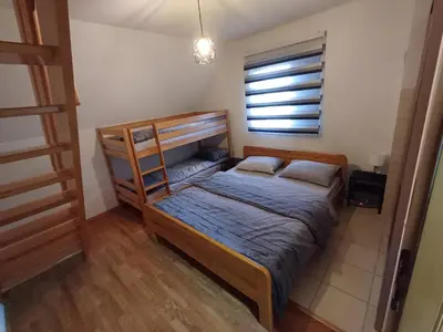 a bedroom with a bunk bed and a window at Vikendica Mila in Kupres