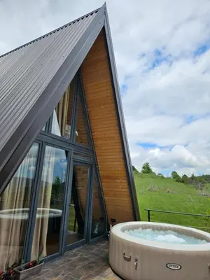 a large building with a hot tub on a patio at Under Sky House - Vikendica - Manjača in Ključ